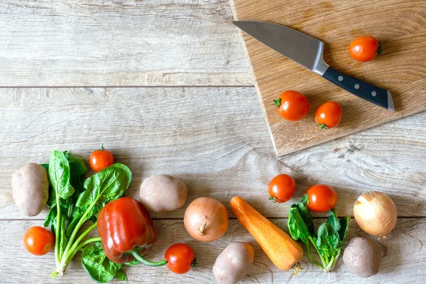 コピースペースのある素朴な木製の背景テーブルの上にナイフで机を切る上で有機野菜とバイオ新鮮な野菜 健康的な自然な熟した菜食主義の野菜の概念 サラダの具材が列に並ぶ — ストック写真