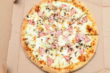 Pastırma, peynir, soğan ve mozzarella ile birlikte servis kutusunda pişmiş sıcak, lezzetli ve taze ev yapımı pizza Carbonara 'nın en üstteki manzarasını kapat.