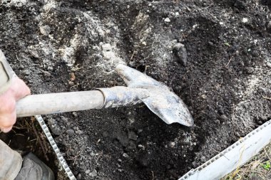 İnsan toprağı kazar, kürekli toprağı, sebze bahçesini, külleri serper, ilkbaharda ya da yazın kırlarda ekme işlemi, tarım, tarım, tarım kavramı.