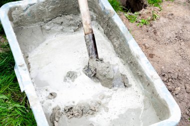 Karıştırma, karıştırma çimento, beton harç büyük kâsede kürek, su deposu, yalak, kova. İnşaat süreci, yenileme, temel atma hazırlıkları.