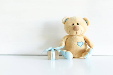 Beyaz masa arkasında hediye kutusu olan, fotokopi alanı olan oyuncak bir oyuncak. Bebek partisi, erkek çocuk için hediye..