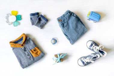 Farklı çocuk oyuncakları, kıyafetler, aksesuarlar, beyaz masa üzerinde fotokopi alanı olan hediye kutusu, düz yatak. Bebek partisi, dekorasyon, eşyalar, erkek kıza hediye ilk yıl doğum günü, yeni doğan partisi.