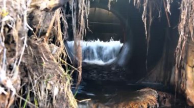 Kirli lağım suyunu nehirden taşıyan beton boru. Kanalizasyon, tedavi tesisleri. Çevre kirliliği, ekoloji sorunları. Kentsel atık kirliliği. Tüp sistemi su baskını koruması
