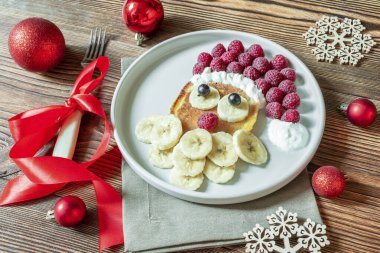 Noel Baba, çocukların kahvaltısı için taze ahududu ve muzlu krep hazırladı. Yılbaşı süslemeleri olan xmas yemekleri kapanıyor..