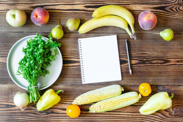 新鮮な果物や野菜と夕食のためのダイエットフィットネス菜食主義者の食べ物 ノートブックとペンで痩身計画木製の背景上のビューのコピースペースフレームフラットフラットレイアウト上のノートのための — ストック写真