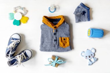 Farklı çocuk oyuncakları, kıyafetler, aksesuarlar, beyaz masa üzerinde fotokopi alanı olan hediye kutusu, düz yatak. Bebek partisi, dekorasyon, eşyalar, erkek kıza hediye ilk yıl doğum günü, yeni doğan partisi.