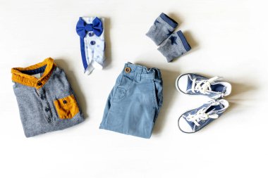 Farklı çocuk kıyafetleri, ayakkabıları, ayakkabıları, pantolonları, aksesuarları fotokopi masası, düz yataklar. Bebek partisi, dekorasyon, eşyalar, erkek çocuğun doğum günü hediyesi, yeni doğan partisi..