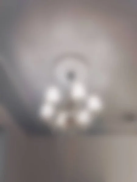 焦点を当てていない背景現代の明るい天井ランプ 新しい家のインテリアデザインの美しいクリスタルシャンデリア — ストック写真