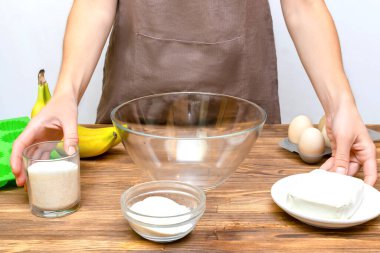 Beyaz önlüklü kadın şef ev mutfağında süzme peynirli muzlu kek, kek güveç, online yemek pişirme, yemek tarifi...