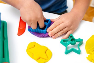 Çocuk oyun oynuyor, plastik kalıplar yapıyor. Kil kaplamalı heykeller yapıyor. Oyun hamuru. Sanat yaratıcılığı, anaokulunda zanaat..