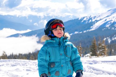 Aktif, kasklı, gözlüklü, yakışıklı çocuk. Dağlarda kayak yapmayı öğreniyor. Kış tatilinde.