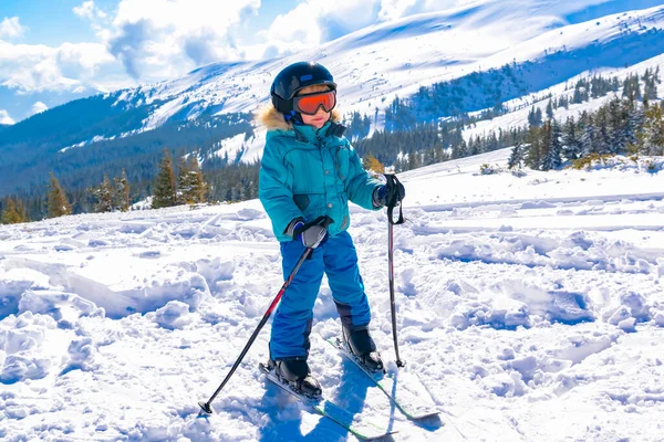 Aktif, kasklı, gözlüklü, yakışıklı çocuk. Dağlarda kayak yapmayı öğreniyor. Kış tatilinde.