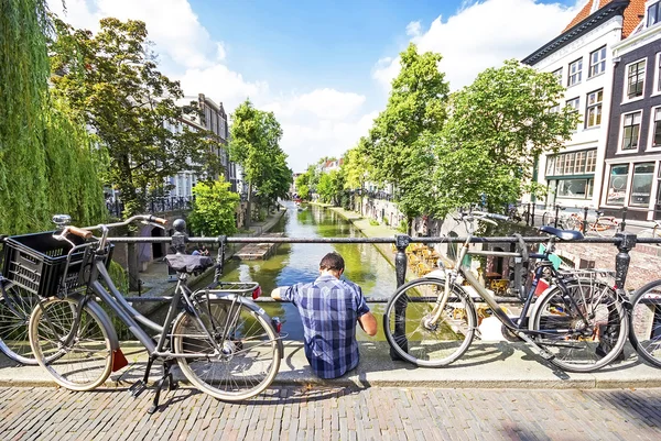 Um homem sentado em uma ponte de Utrecht, Países Baixos Fotografia De Stock