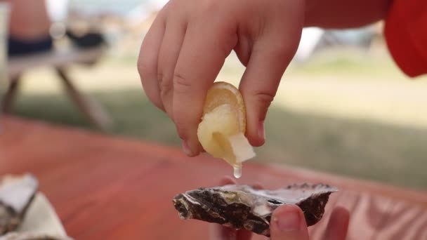 Childs mano exprime jugo de limón en ostra — Vídeos de Stock