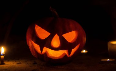 Cadılar bayramında karanlıkta mumlarla dolu balkabağı kafası