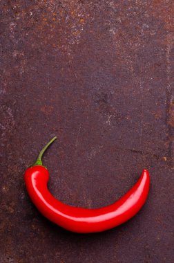 Paslı kahverengi metal arka planda kırmızı biber kabuğu. Tasarım konsepti. Seçici odak.