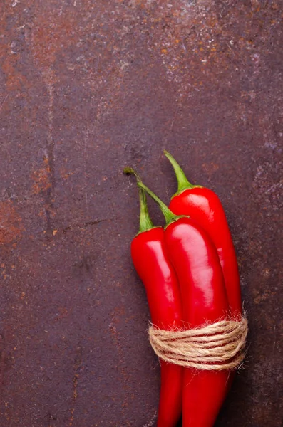 Red pepper pod on a rusty brown metal background. Design concept. Selective focus.