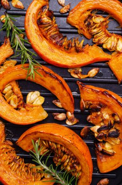 Kavrulmuş kabak dilimleri, tohumlar ve biberiye. Seçici odak.