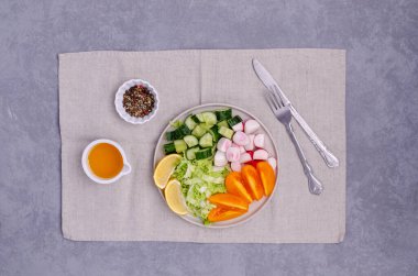 Gri taşlı arka planda sebze dilimlerini bir tabakta karıştır. Seçici odak.