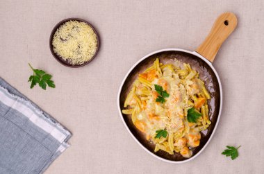 Beyaz soslu balkabaklı makarna. Tekstil arka planında seramik bir kapta. Seçici odak.