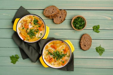 Ahşap arka planda seramik tabakta sebzeli makarna güveci. Seçici odak.