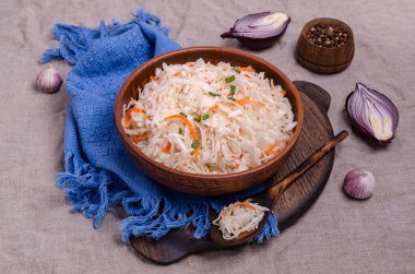 Sauerkraut salad with carrots in a dish on a textile background. Selective focus.