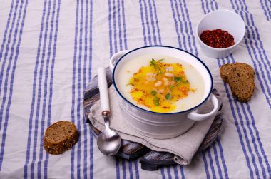 Fasulyeli sebze kremalı çorba ve tekstil arka planında baharatlı yağ. Seçici odak.