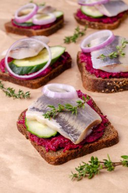 Kağıt üzerinde sebzeli sandviç ve ringa balığı. Seçici odak.