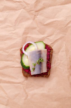 Kağıt üzerinde sebzeli sandviç ve ringa balığı. Seçici odak.