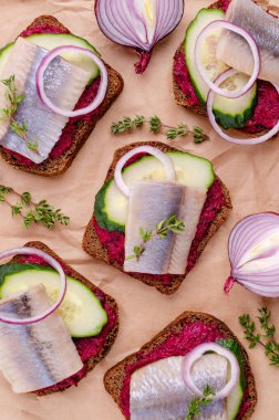 Kağıt üzerinde sebzeli sandviç ve ringa balığı. Seçici odak.