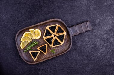 Siyah arka planda siyah havyarlı turtalar. Üst Manzara. Seçici odak.