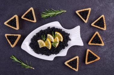 Siyah arka planda siyah havyarlı turtalar. Üst Manzara. Seçici odak.