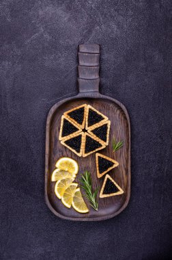 Siyah arka planda siyah havyarlı turtalar. Üst Manzara. Seçici odak.