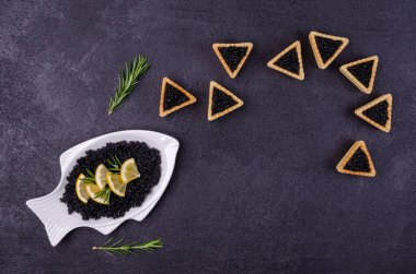 Siyah arka planda siyah havyarlı turtalar. Üst Manzara. Seçici odak.