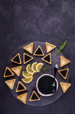 Siyah arka planda siyah havyarlı turtalar. Üst Manzara. Seçici odak.