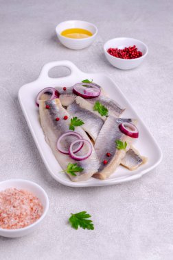 Gri arkaplanlı tuzlu ringa fileto. Seçici odak.