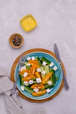 Taze sebze salatası. Salatalık dilimleri, sarı domates, beyaz peynir ve bezelye filizi. Üst Manzara. Gri arkaplan.