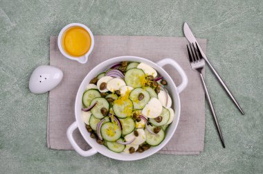 Yeşil arka planda salatalık, peynir, kapari ve limon tatlısı salatası. Üst Manzara. Seçici odak.