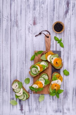 Sebzeli sandviç, peynir ve ahşap arka planda yeşil sos. Üst görünüm.