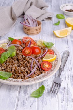 Ahşap arka planda karabuğday ve sebzeli salata. Seçici odak.