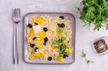 Sebzeli küçük makarna ve çimento arka planında bir tabakta bezelye filizi. Üst Manzara. Seçici odak.