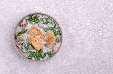 Kızarmış kuş göğsü ve çimento arka planında beyaz soslu haşlanmış sebzeler. Üst Manzara. Seçici odak.