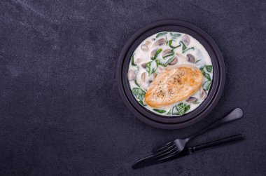 Kızarmış kuş göğsü ve çimento arka planında beyaz soslu haşlanmış sebzeler. Üst Manzara. Seçici odak.