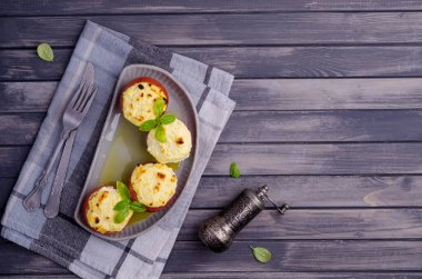 Ahşap arka planda peynirle doldurulmuş haşlanmış domatesler. Seçici odak.