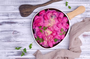 Krema soslu Gnocchi, ahşap arka planda pazı yaprakları ve sapları. Üst görünüm.