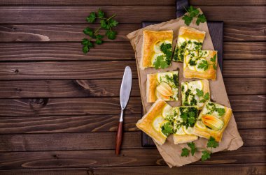 Ahşap arka planda yeşil soslu yuvarlak sebze turtası. Üst Manzara. Seçici odak.