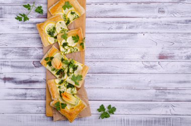 Ahşap arka planda yeşil soslu yuvarlak sebze turtası. Üst Manzara. Seçici odak.