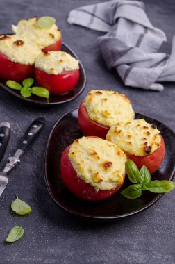 Taş bir arka planda peynirle doldurulmuş domates yahnisi. Seçici odak.