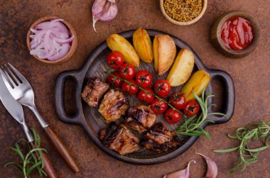 Eski metal bir arka planda sebzeli ve baharatlı kızarmış et dilimleri. Seçici odak.