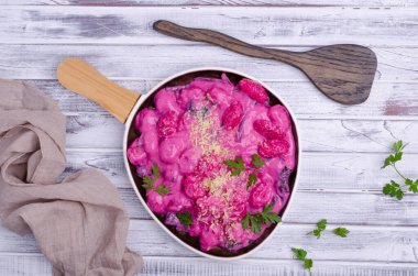 Krema soslu Gnocchi, ahşap arka planda pazı yaprakları ve sapları. Üst görünüm.